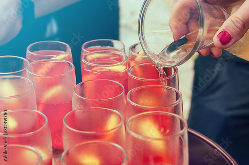 Glasses of spritz. Woman's hand prepares typical Italian drinks by pouring wine (selective focus)
