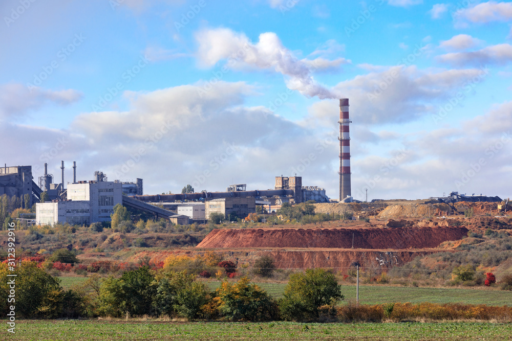 Cement factory on the background of a quarry of limestone and clay on a summer day.