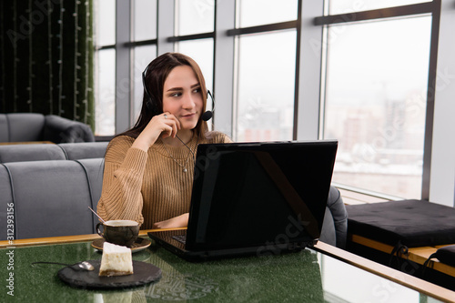 girl leads some online broadcast from the coffee shop and thought for a second