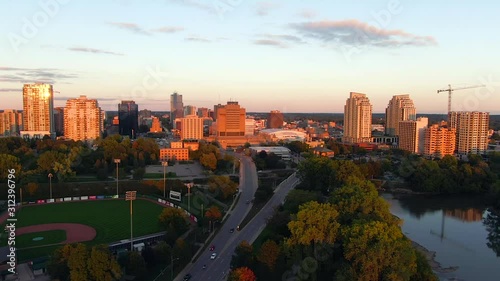 Aerial flying over Thames river with view downtown London Ontario during golden hour sunset photo