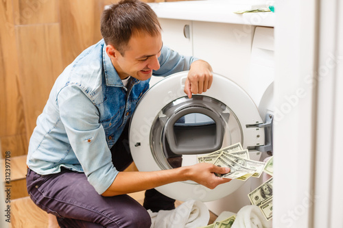 Female putting money into washing machine, closeup