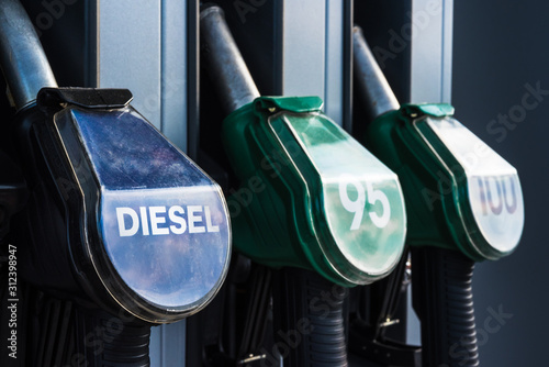 Diesel text, 95 and 100 high octane and quality gasoline numbers on fuel pistols of gas station refuelling stand - transportation, oil business or environmental pollution theme closeup background photo