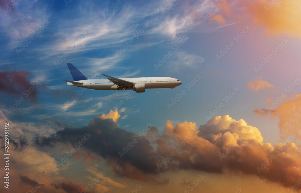 Airplane in the sky in dramatic sunset and sunrise sky.