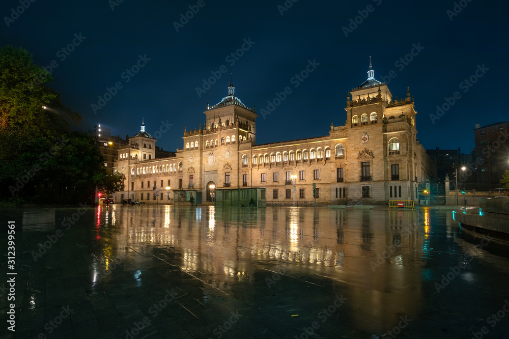 Valladolid, Spain. View of Zorrilla square at dusk with building of Cavalry Academy reflecting in water