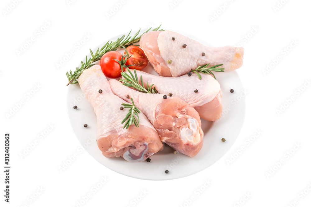 Raw chicken drumstick or legs in a plate with herbs and spices isolated on white background Raw chicken drumstick or legs in a plate with herbs and spices isolated on white background