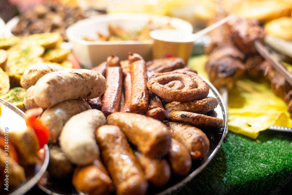 Pork, beef and paprika sausages, hot dogs and other appetizing, warming and usually unhealthy street fast food on an Christmas market Pork, beef and paprika sausages, hot dogs and other appetizing, warming and usually unhealthy street fast food on an Christmas market