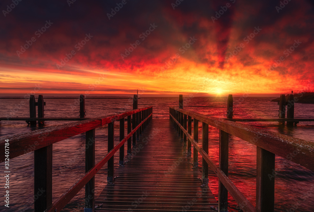 wooden pier at sunrise on sea