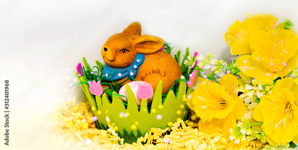 Easter bunny with eggs in a green easter basket on white background, flower decoration and space for text Easter bunny with eggs in a green easter basket on white background, flower decoration and space for text