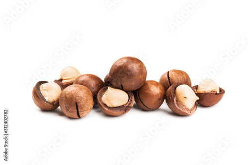 Raw not peeled whole macadamia nuts with shelled kernels isolated on white. Macro view. Healthy food. Protein source.