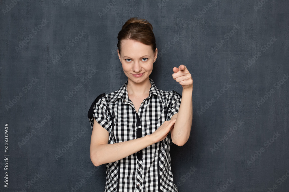 Portrait of happy young woman smiling and pointing with finger at you Portrait of happy young woman smiling and pointing with finger at you