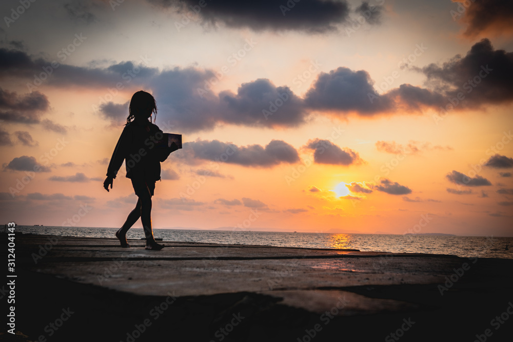silhouette of girl running on the beach at sunset