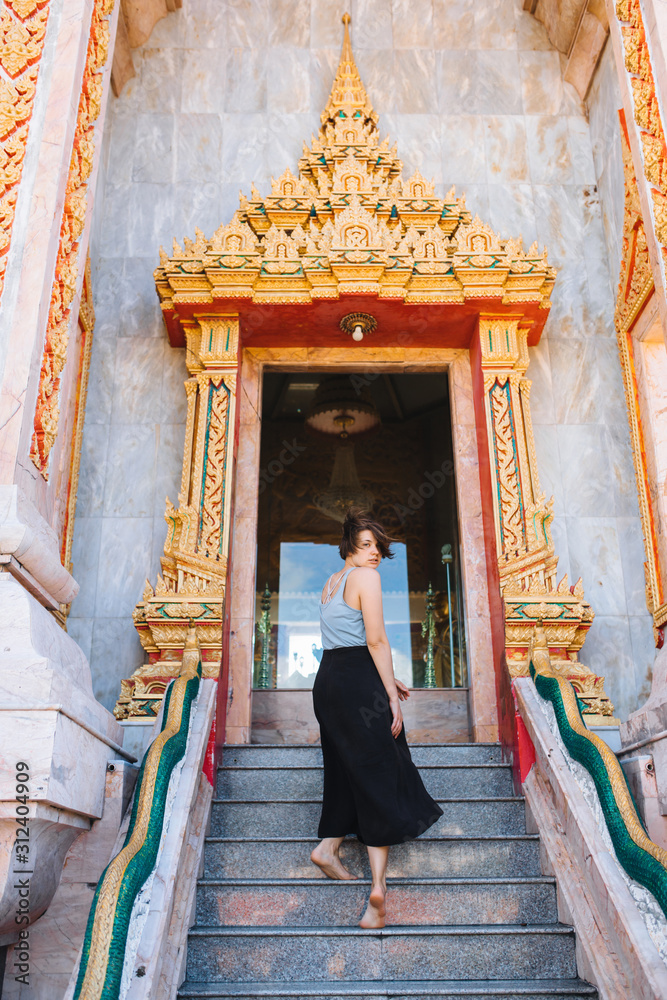A girl runs on the steps of a Buddhist temple in Thailand