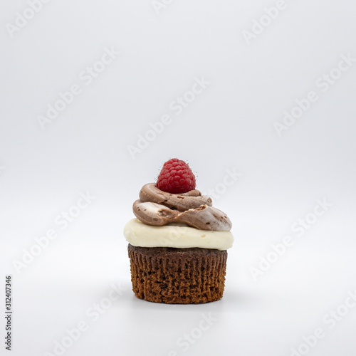 chocolate cupcake with frosting and raspberry garnish