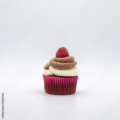 chocolate cupcake with frosting and raspberry garnish