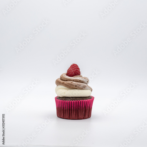 chocolate cupcake with frosting and raspberry garnish