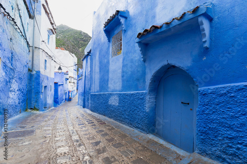 Fototapeta Naklejka Na Ścianę i Meble -  Traditional typical moroccan architectural details in Chefchaouen, Morocco, Africa Beautiful street of blue medina with blue walls and decorated with various objects (pots, jugs). A city with narrow, 