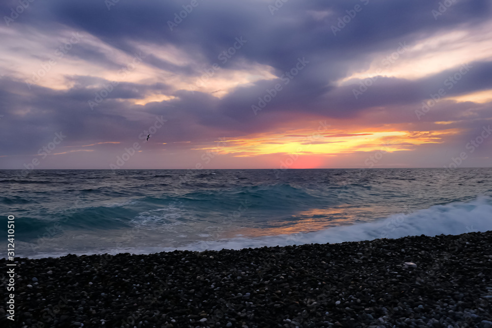 Obraz premium waves of the ocean surf evening before a thunderstorm. Sunset over the ocean