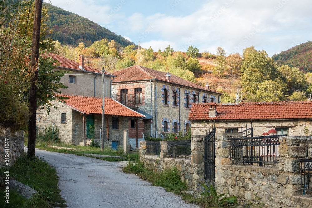 Street in the mountainous Kratero village in Florina, Greece, with old stone houses and Autumn colours