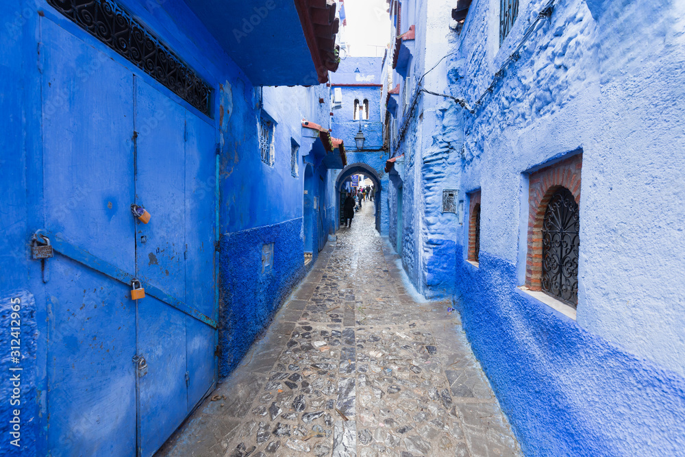 Traditional typical moroccan architectural details in Chefchaouen, Morocco, Africa Beautiful street of blue medina with blue walls and decorated with various objects (pots, jugs). A city with narrow, 