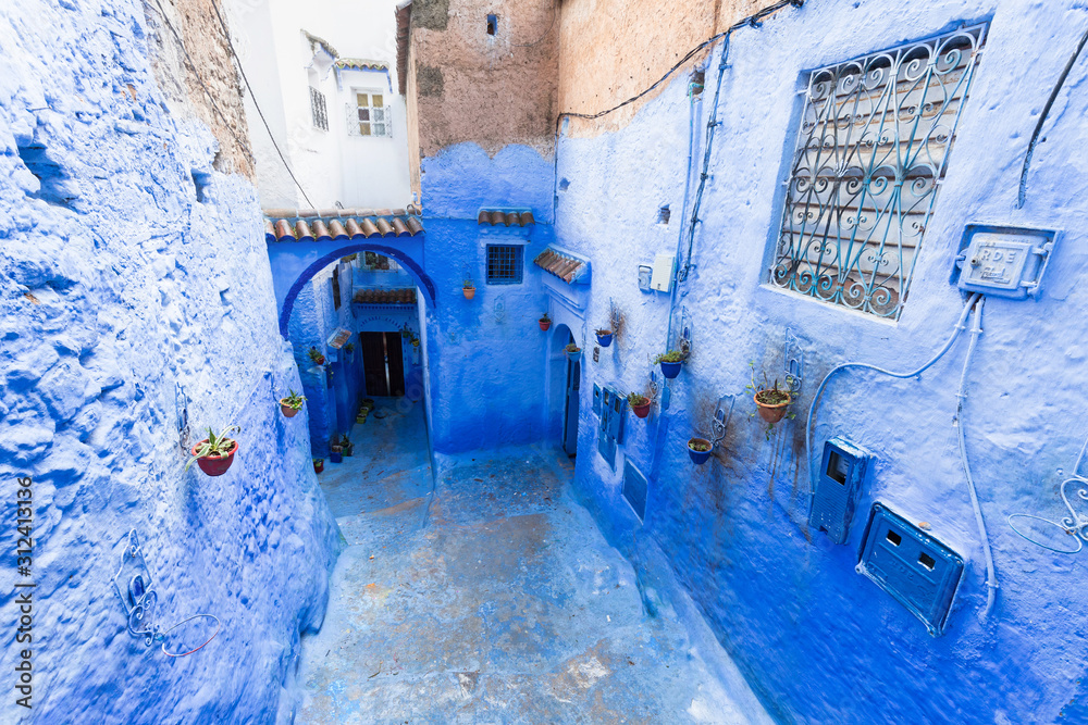 Traditional typical moroccan architectural details in Chefchaouen, Morocco, Africa Beautiful street of blue medina with blue walls and decorated with various objects (pots, jugs). A city with narrow, 