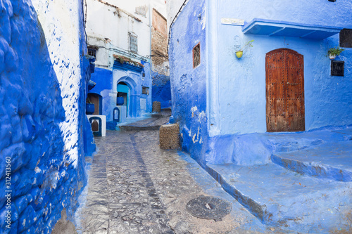Traditional typical moroccan architectural details in Chefchaouen, Morocco, Africa Beautiful street of blue medina with blue walls and decorated with various objects (pots, jugs). A city with narrow,  © Michal