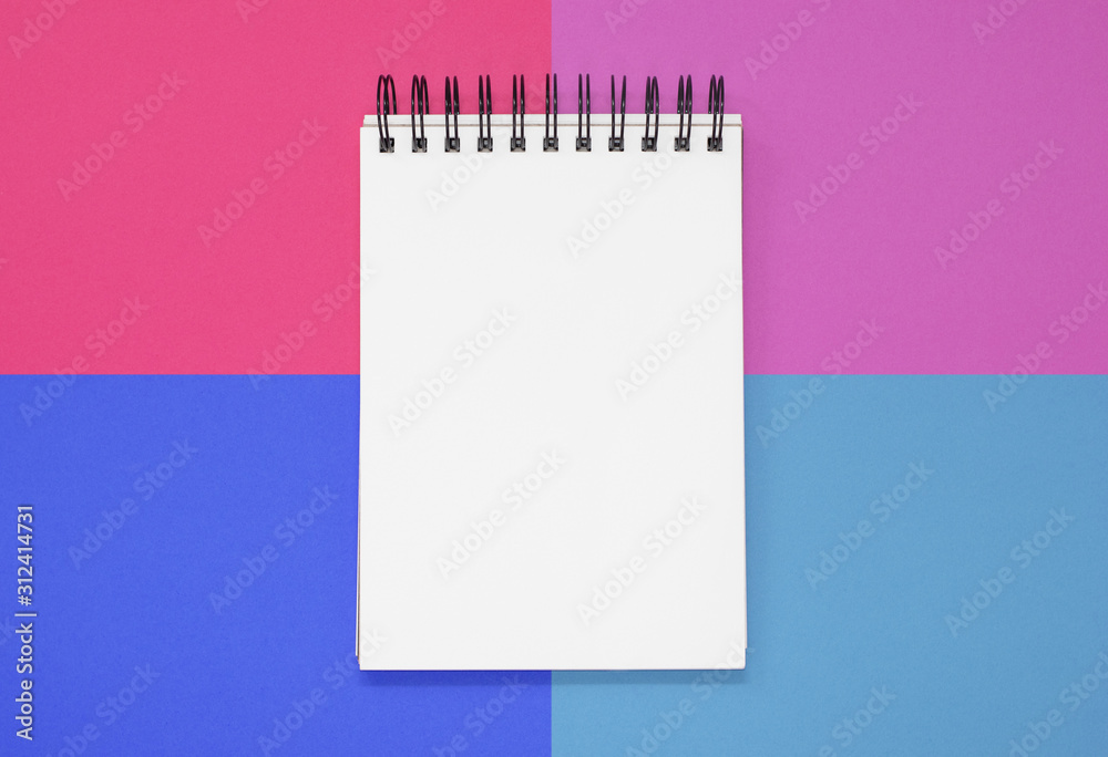 Open notepad on a pink and blue square background. Top view with copy space Open notepad on a pink and blue square background. Top view with copy space