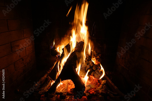 Cosy fireplace with reddish fire as seen during Christmas holidays