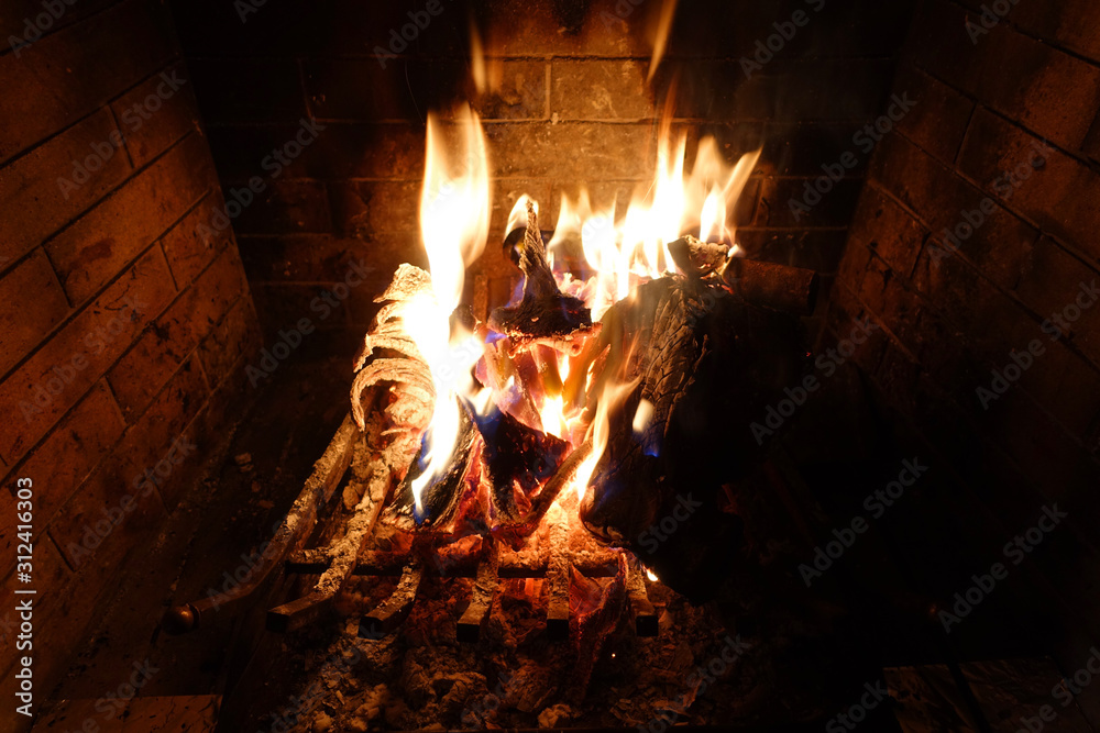 Cosy fireplace with reddish fire as seen during Christmas holidays Cosy fireplace with reddish fire as seen during Christmas holidays