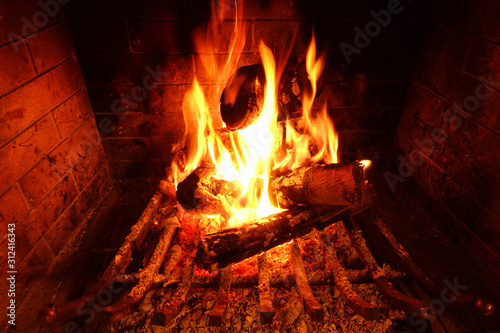 Cosy fireplace with reddish fire as seen during Christmas holidays