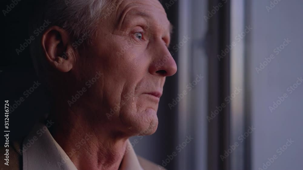 Sad old man crying near window, suffering loneliness, abandoned by relatives