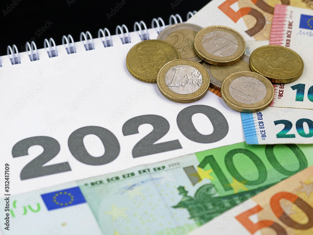 euro banknotes and coins on calendar 2020, concept of expenditure or taxes payment, cost in the new year euro banknotes and coins on calendar 2020, concept of expenditure or taxes payment, cost in the new year