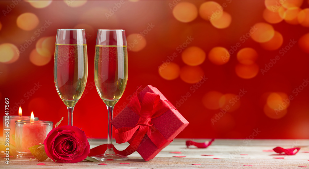 Red roses, gift box and champagne glasses on wooden background. Special occasions dinner background. Backgrounds for special days ( Christmas, New Year, Valentine's Day, Wedding Anniversary, birthday Red roses, gift box and champagne glasses on wooden background. Special occasions dinner background. Backgrounds for special days ( Christmas, New Year, Valentine's Day, Wedding Anniversary, birthday