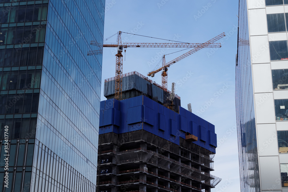 Fototapeta premium Cranes on the construction site of skyscraper