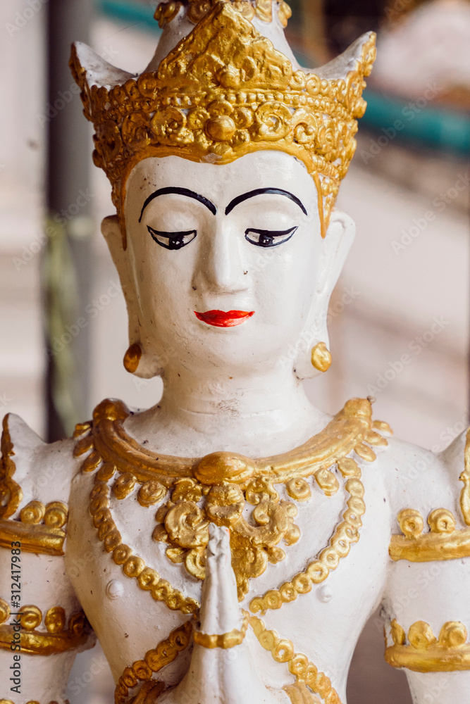 Small sacred statue of a Buddha in Bangkok. Travel to Asia and holidays concept. Buddhist religion, ancient art and asian heritage culture. Visit sacred luxury temples and sightseeing in Thailand.
