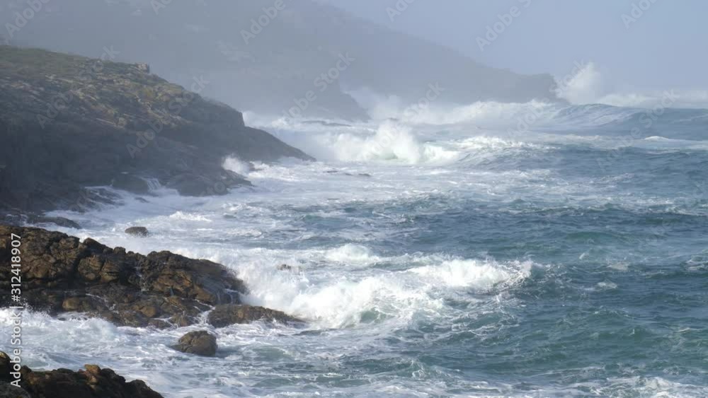 Wild and roaring Atlantic. The water seems to be boiling. The spray is flying high in the air. The waves hit the rocks of the Galician coast in northern Spain near the Tourinan lighthouse. Wild and roaring Atlantic. The water seems to be boiling. The spray is flying high in the air. The waves hit the rocks of the Galician coast in northern Spain near the Tourinan lighthouse.
