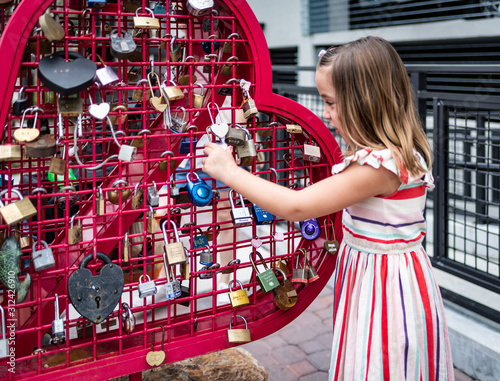 Obraz na plátne Young Girl looking at the love locks in Florida, eye-level, side view