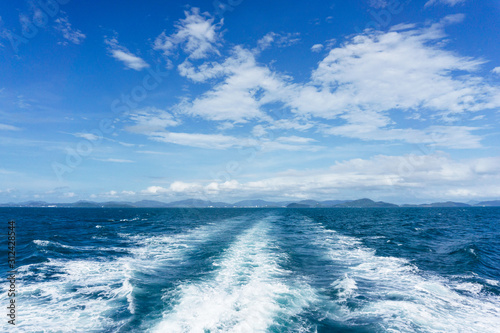 Travelling ferry ocean water. Blue cloudy sky background. Exotic Thailand seascape. Motor boat speed wave.