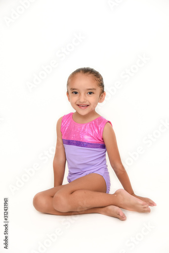 small latin girl doing gymnastics with white background and purple sportswear