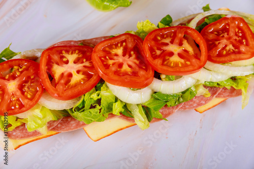 Long sub with muenster cheese, salami and vegetable.