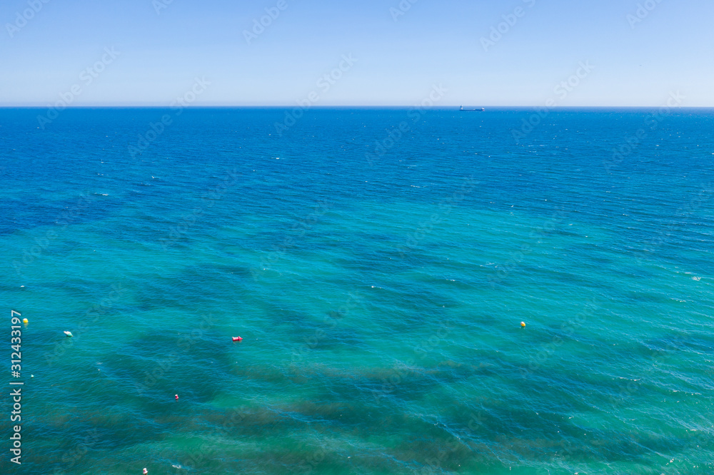 aerial view of the texture of the surface of turquoise water with sun reflections