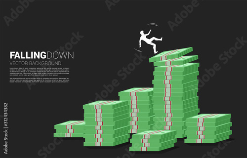 silhouette of businessman slip and falling down from stack of money banknote. Concept for fail and accidental business