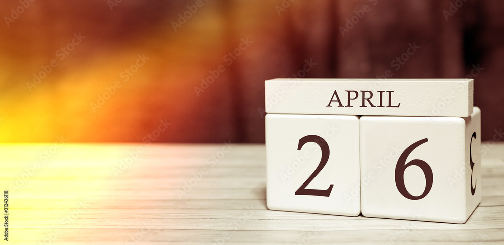 Calendar reminder event concept. Wooden cubes with numbers and month on April 26 with sunlight. Calendar reminder event concept. Wooden cubes with numbers and month on April 26 with sunlight.