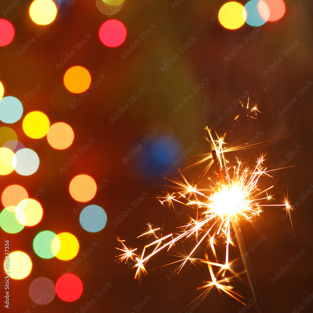 beautiful sparklers on the background of a garland. beautiful holiday card for the New Year. beautiful sparklers on the background of a garland. beautiful holiday card for the New Year.