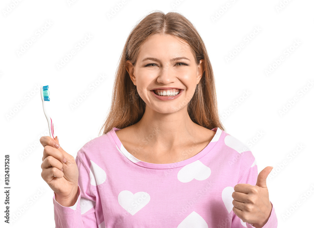 Young woman with toothbrush showing thumb-up on white background Young woman with toothbrush showing thumb-up on white background