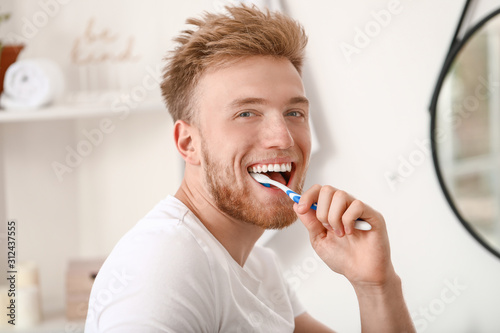 Wallpaper Mural Young man brushing teeth at home