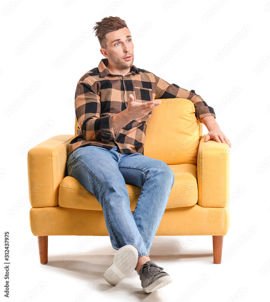 Emotional man sitting in armchair on white background