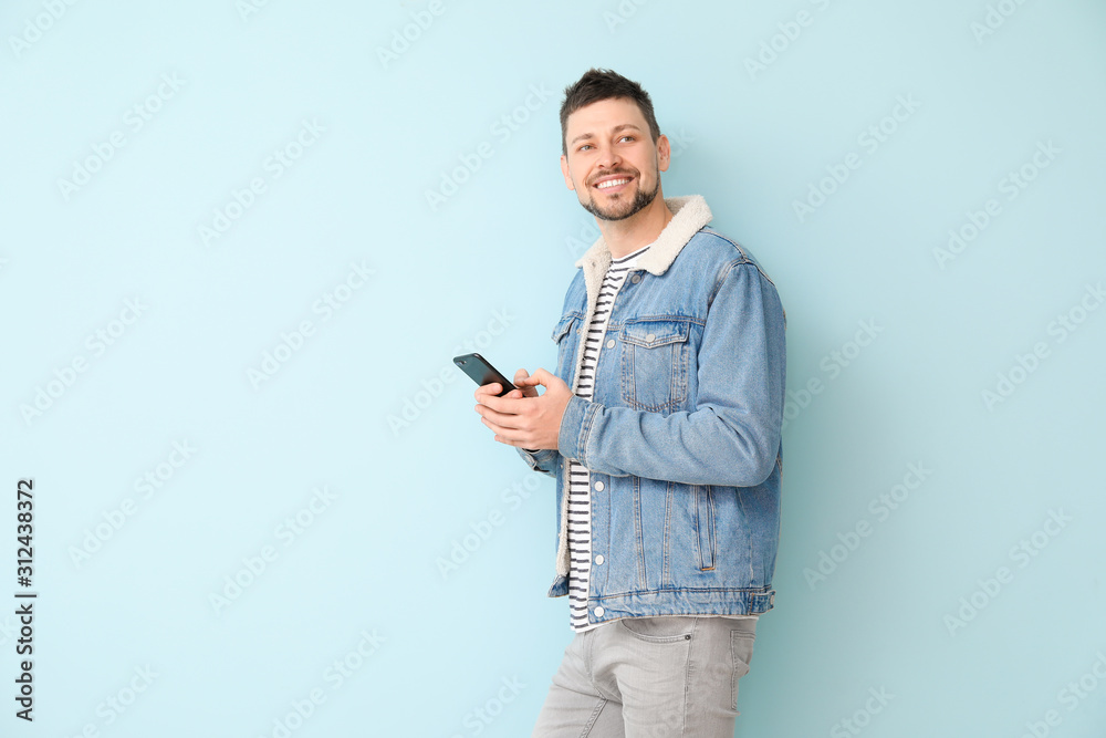 Happy man with mobile phone on color background Happy man with mobile phone on color background