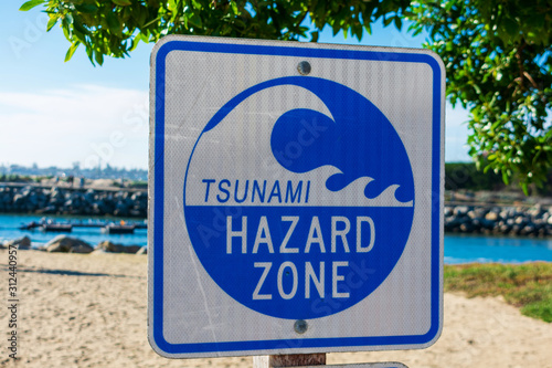Tsunami Hazard Zone warning sign on the Pacific Ocean coast warns public about possible danger after earthquake
