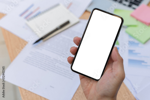 Mockup image blank white screen cell phone.man hand holding texting using mobile on desk at officebackground empty space for advertise text.people contact marketing business,technology  photo