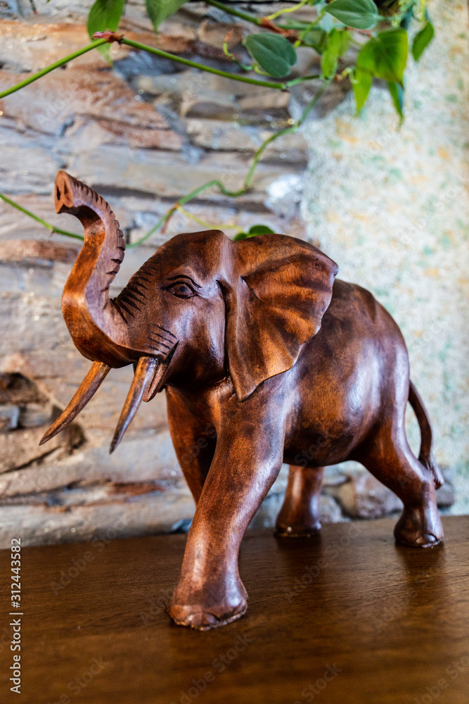 Fototapeta premium cute brown wooden elephant on a background of stones